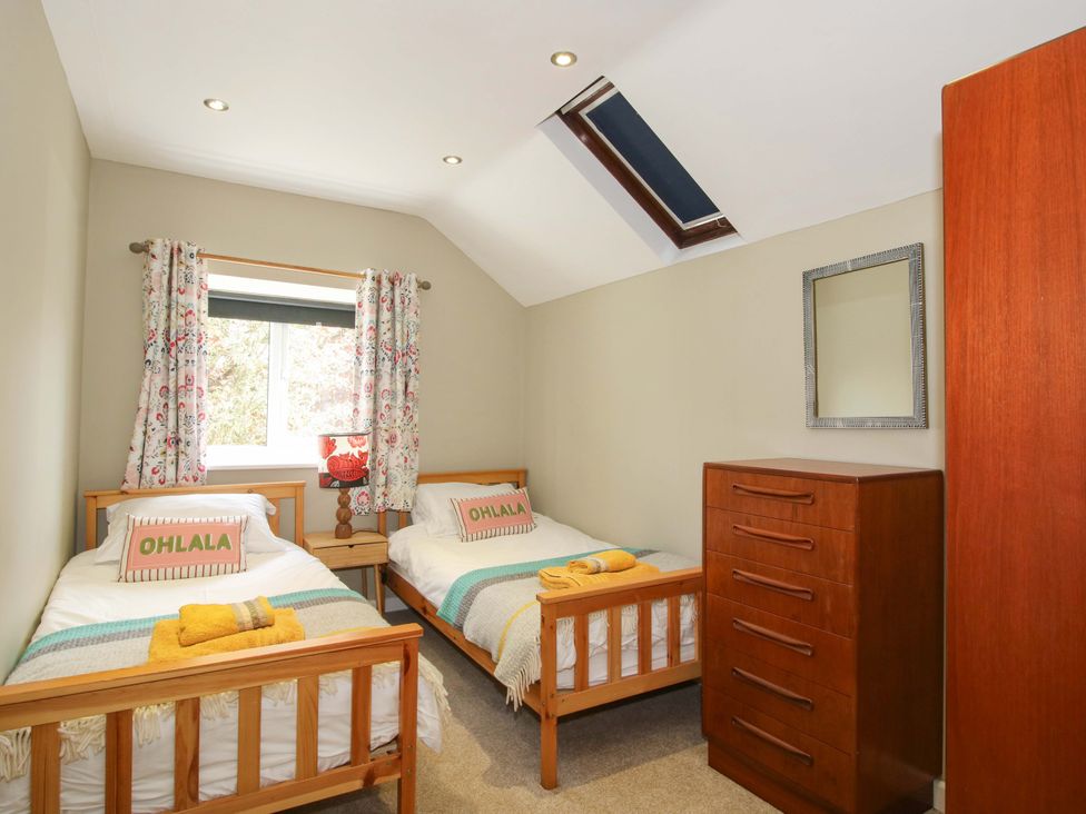 A bedroom with two single beds and a dresser at Pentwyn Barn in Clyro