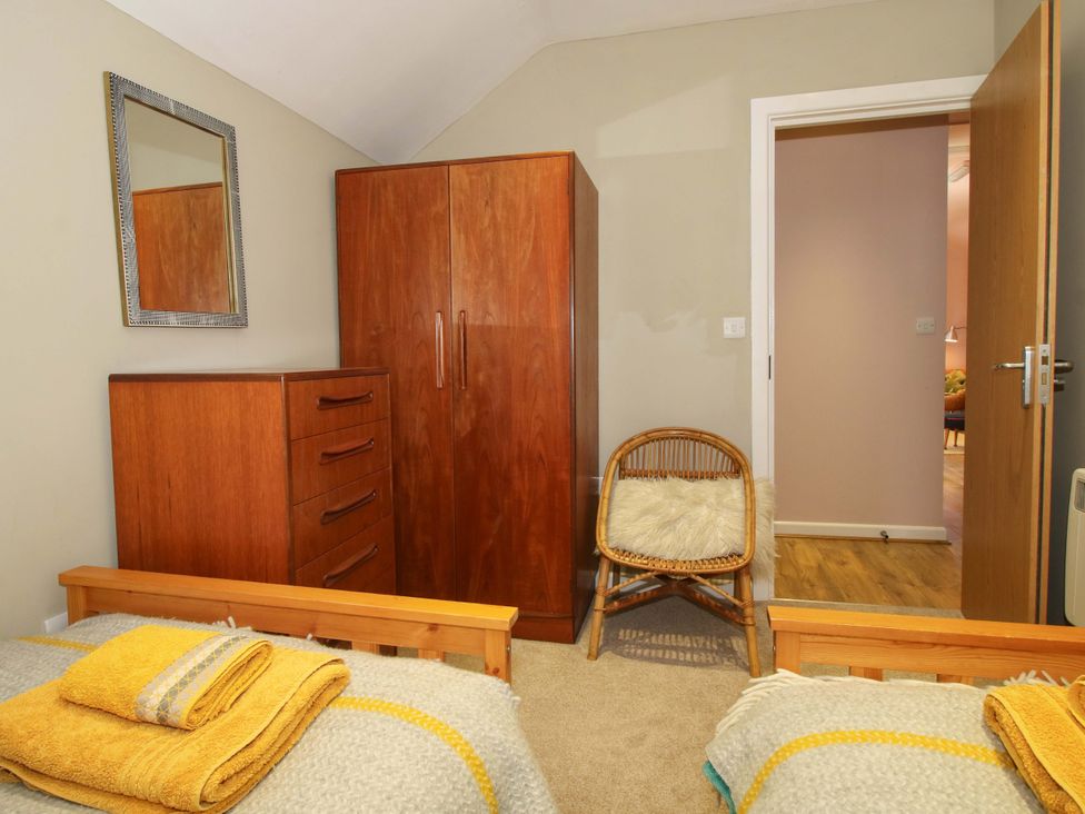 A bedroom with a wardrobe and beds at Pentwyn Barn in Clyro