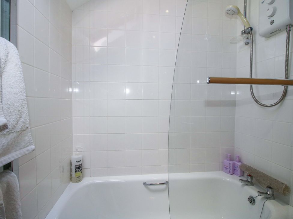 A shower and bathtub with toiletries at Pentwyn Barn in Clyro