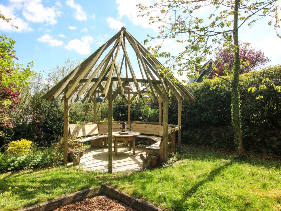 A gazebo with bench and table in the garden at Pentwyn Barn in Clyro