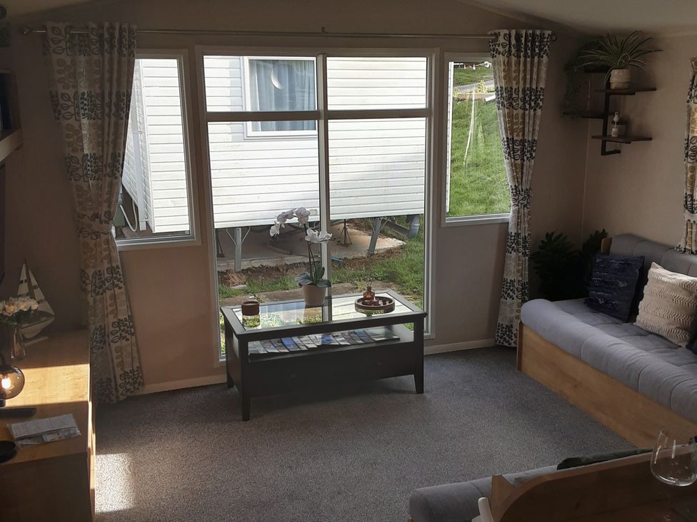 A living room with windows and a sofa at Josephine MB37 in Newquay