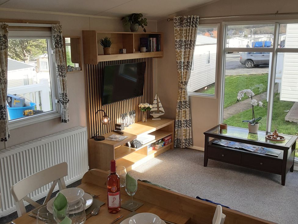 A living room with a television and shelves at Josephine MB37 in Newquay