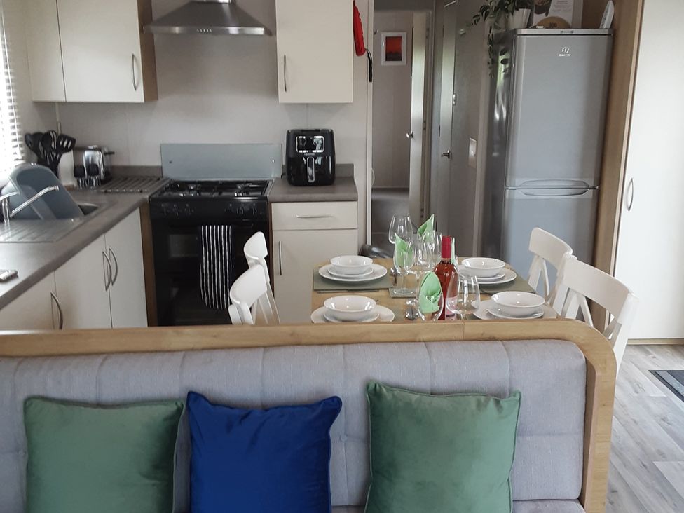 A kitchen with a dining table and chairs at Josephine MB37 in Newquay