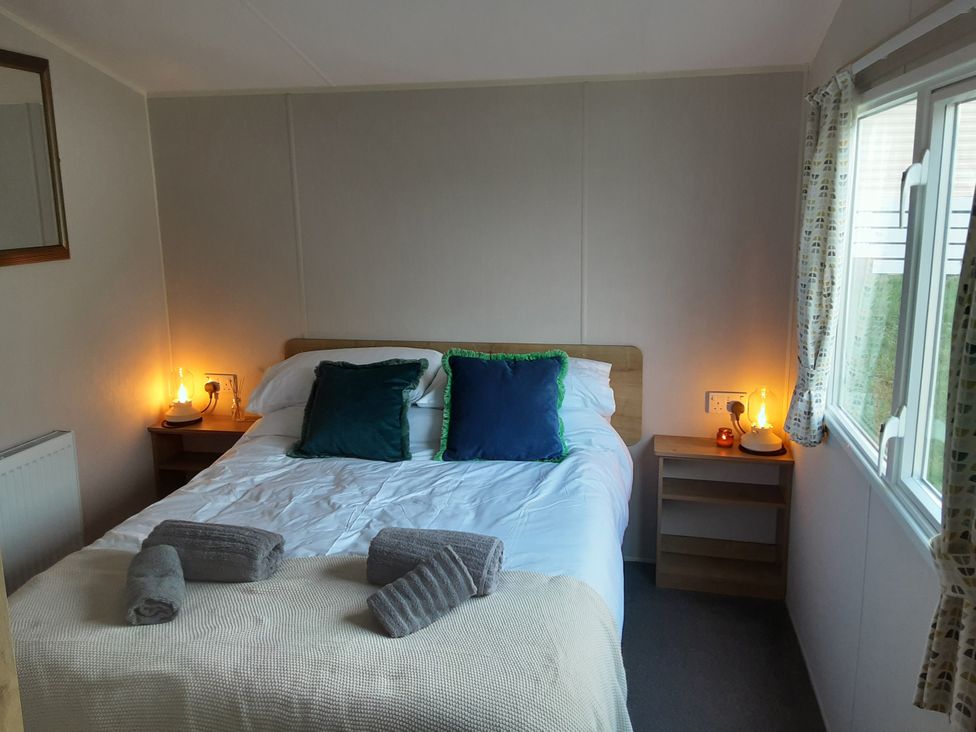 A bedroom with a bed and bedside tables at Josephine MB37 in Newquay