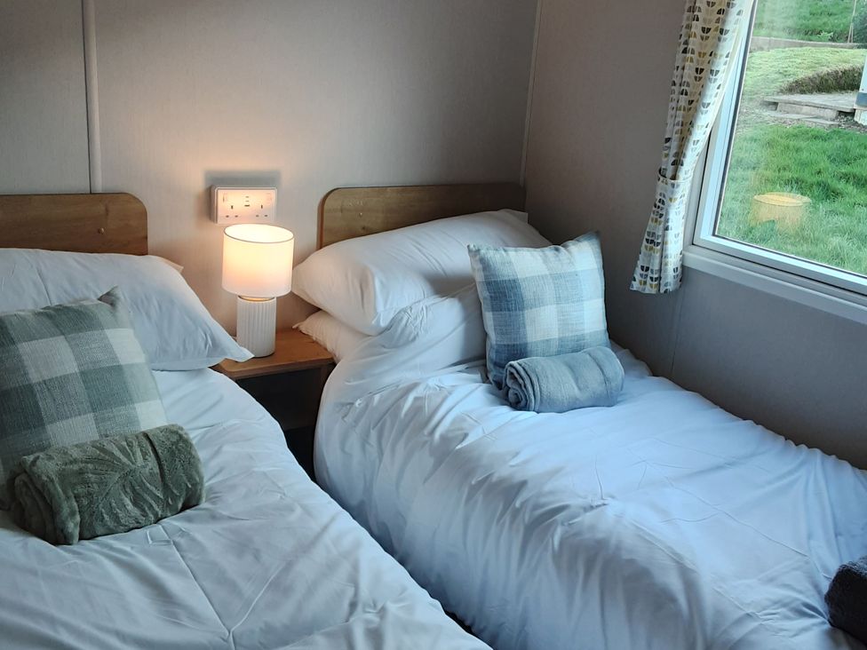 A bedroom with two single beds and a lamp at Josephine MB37 Newquay