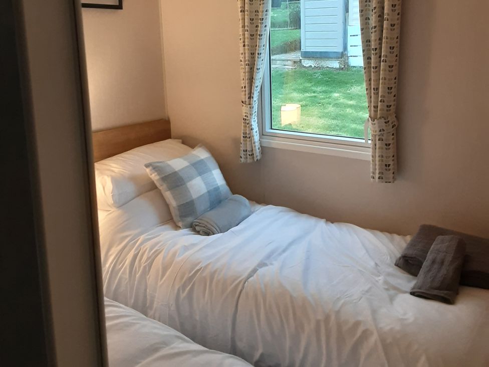 A bedroom with two beds and a window at Josephine MB37 in Newquay