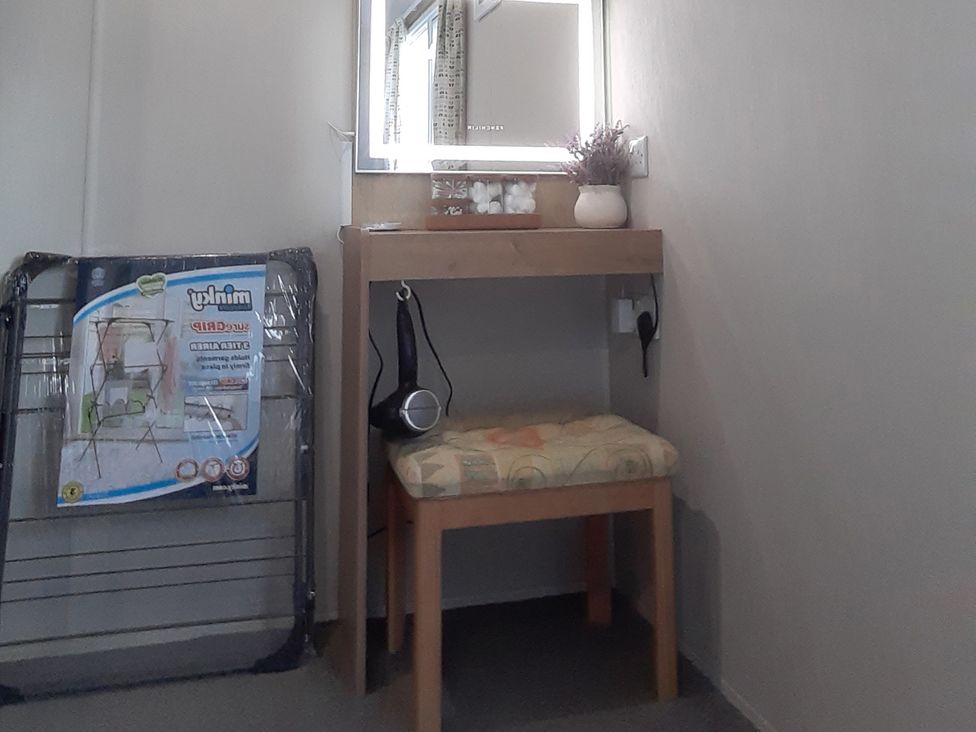 A dressing area with a mirror and stool at Josephine MB37 in Newquay