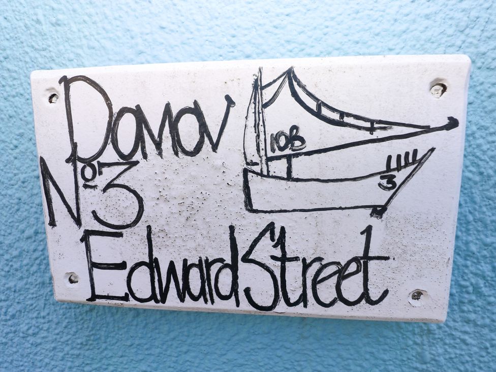 A nameplate displaying a boat drawing and address at 3 Edward Street, Tenby