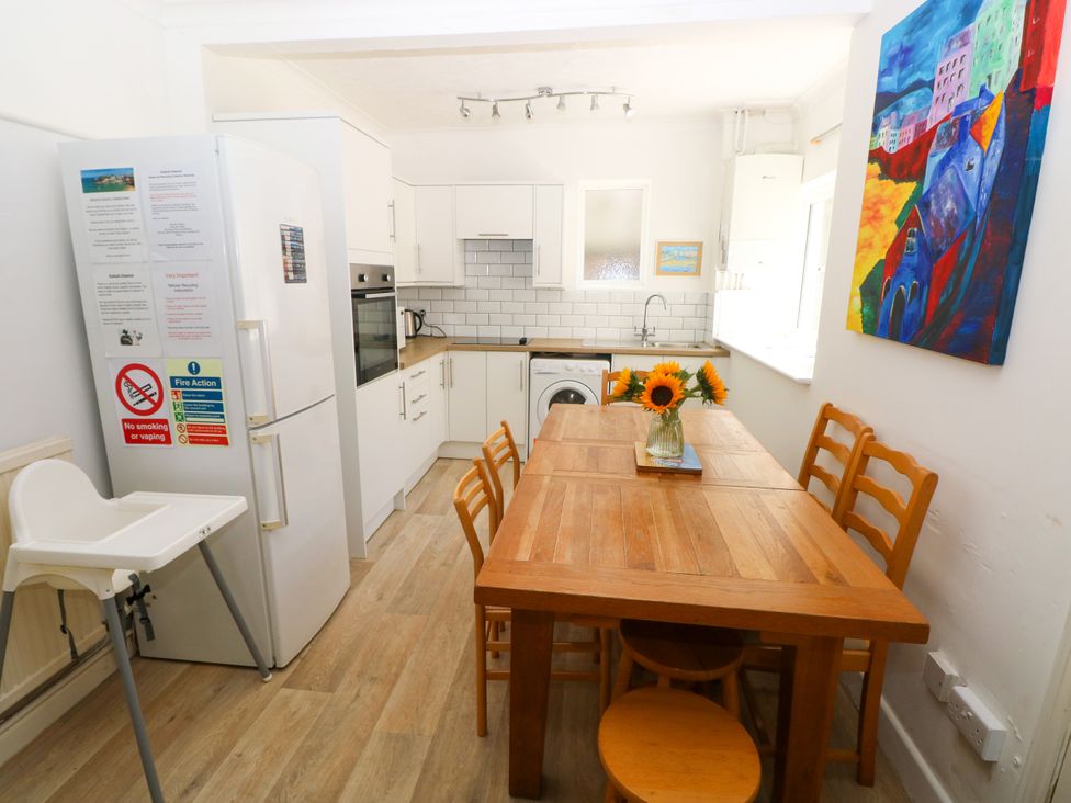 A kitchen with a dining table and appliances at 3 Edward Street Tenby