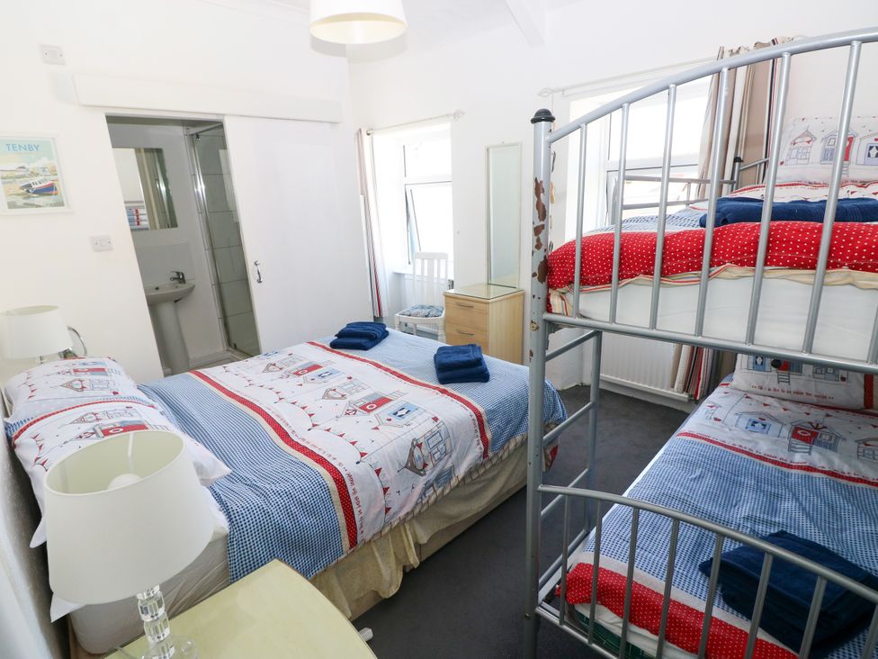 A bedroom with a double bed and bunk bed at 3 Edward Street Tenby