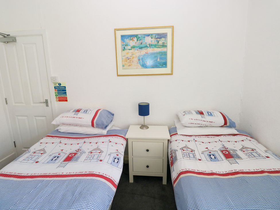A bedroom with two beds and a bedside table at 3 Edward Street, Tenby