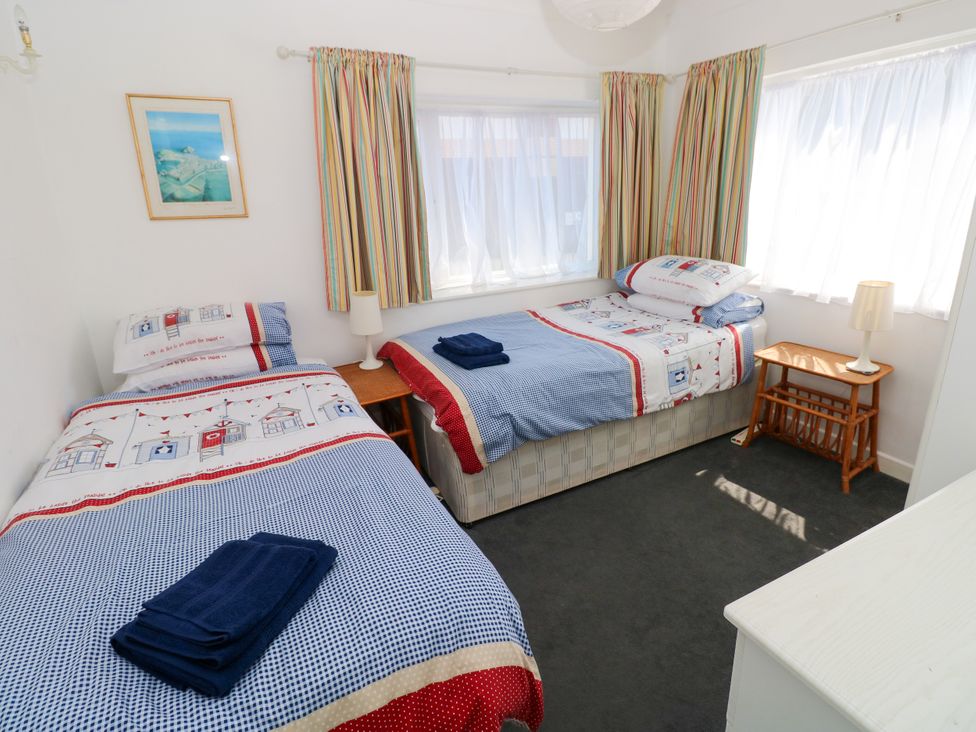 A bedroom with two beds and a bedside table at 3 Edward Street, Tenby