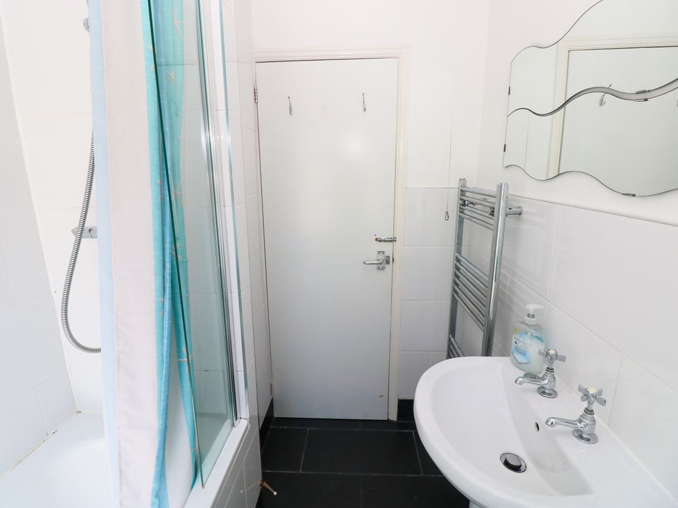 A bathroom with a bathtub and shower at 3 Edward Street Tenby