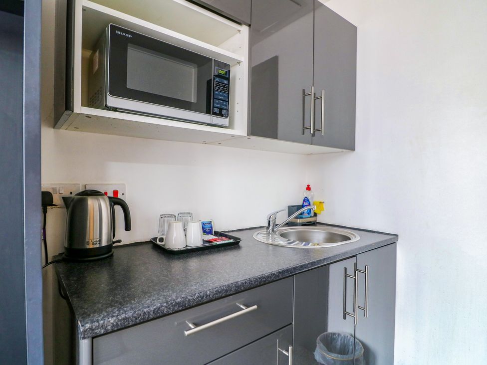 A kitchen with a microwave, kettle, and sink at Apartment 304 in Nottingham