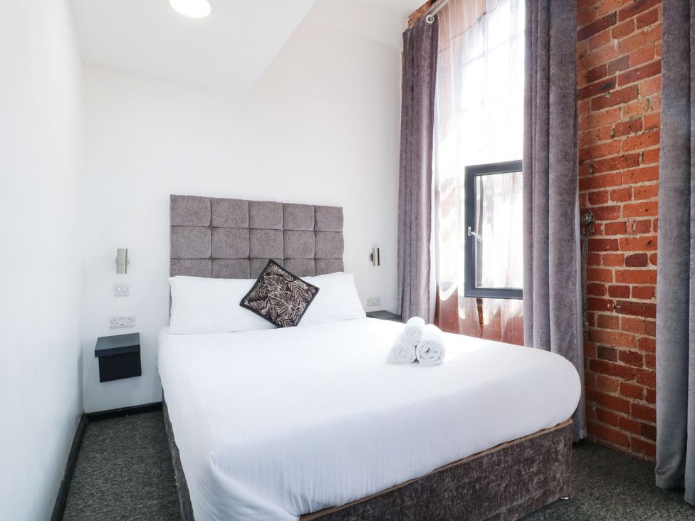 A bedroom with a bed and decorative pillow at Apartment 304 in Nottingham