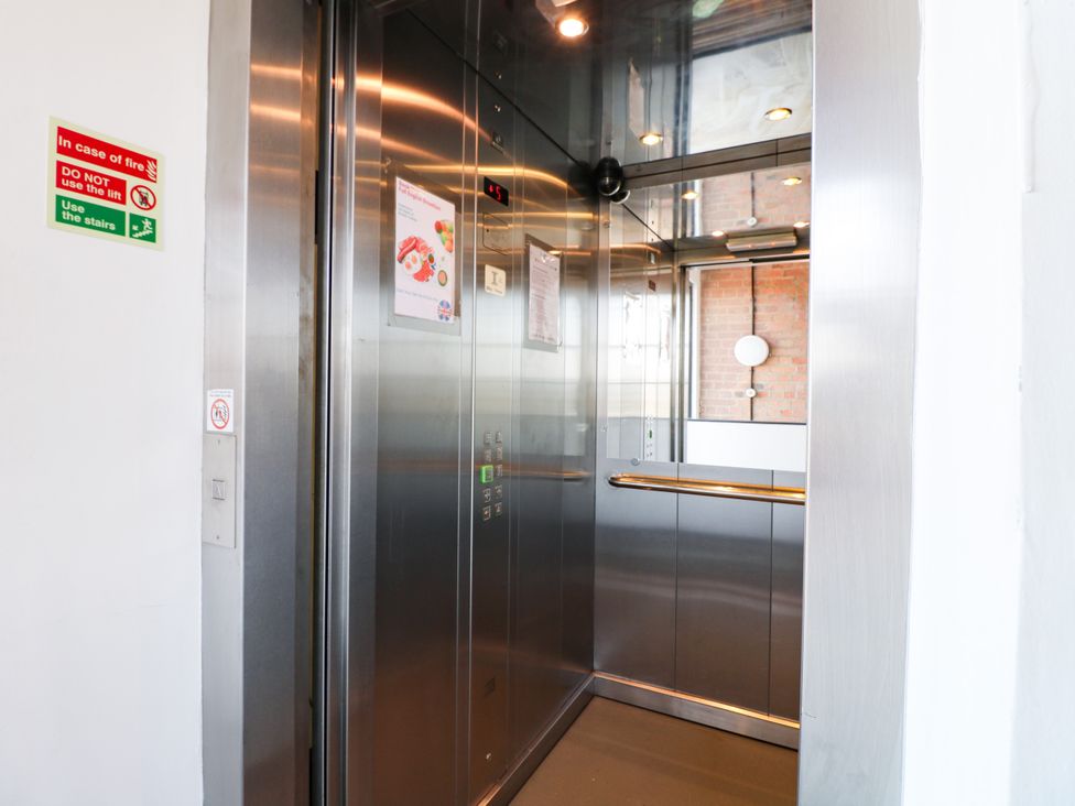 An elevator with buttons and safety signs at Apartment 304 in Nottingham