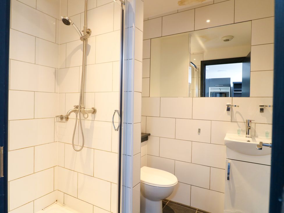 A bathroom with a shower, toilet, and sink at Apartment 310 in Nottingham