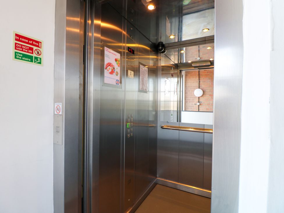 An elevator with control panel and safety sign at Apartment 310 in Nottingham