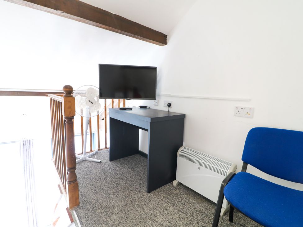 A desk with a television and fan in a loft at Apartment 610 Nottingham