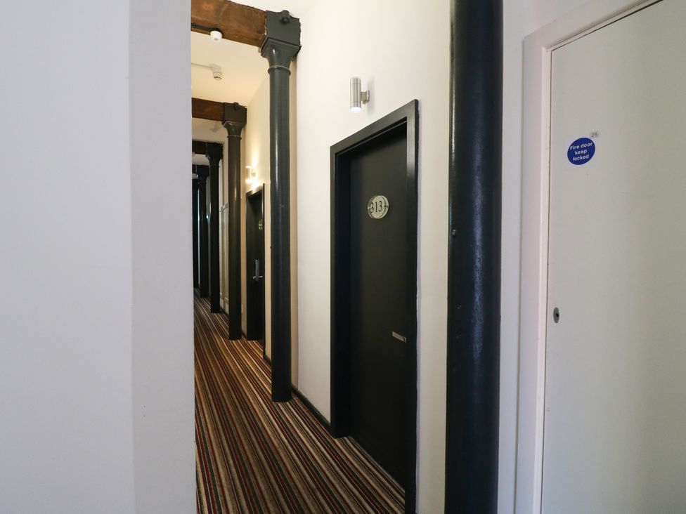 A corridor with doors and support columns at Apartment 610 Nottingham