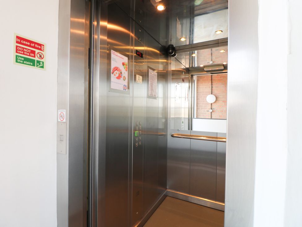 An elevator interior with buttons and signage at Apartment 610 in Nottingham