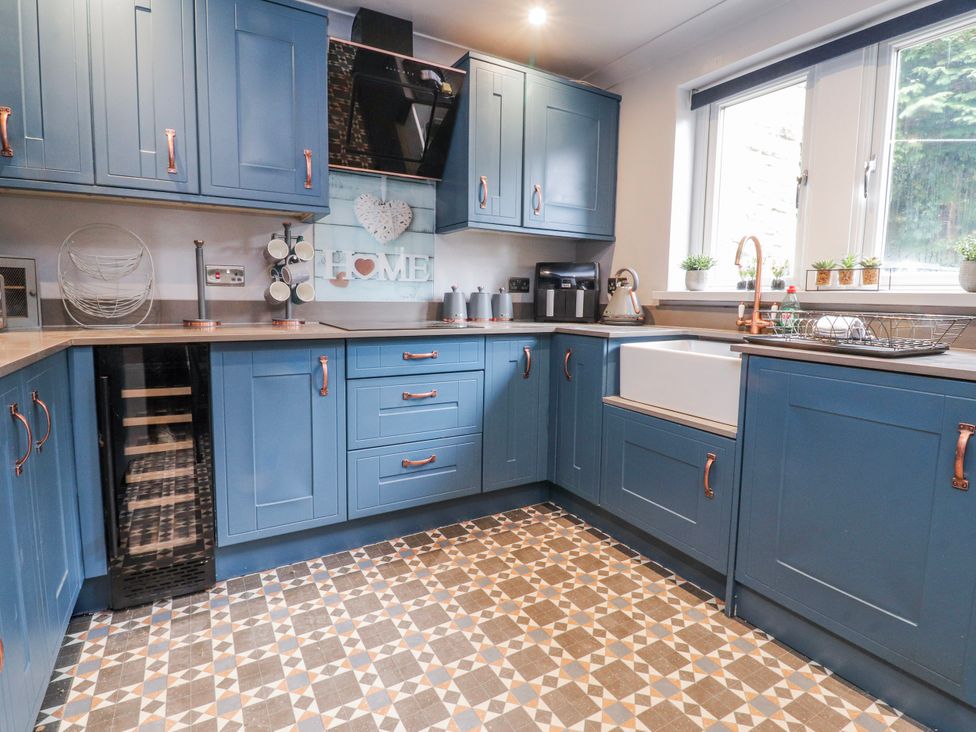 A kitchen with blue cabinets and a coffee machine at 2 Rock View Settle