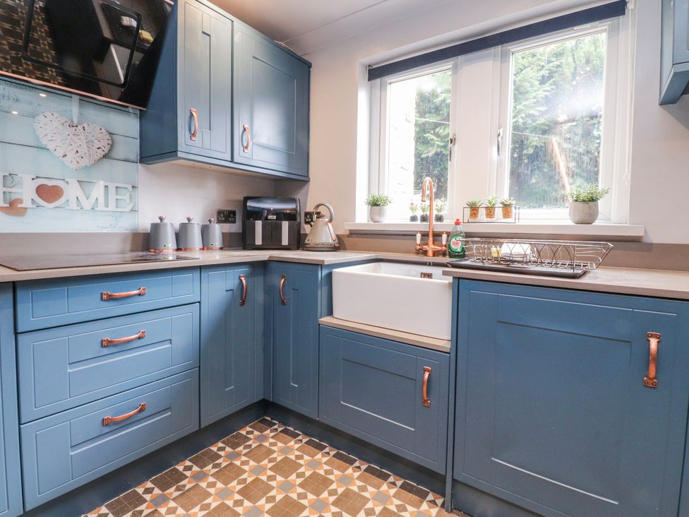 A kitchen with blue cabinets and a white sink at 2 Rock View in Settle