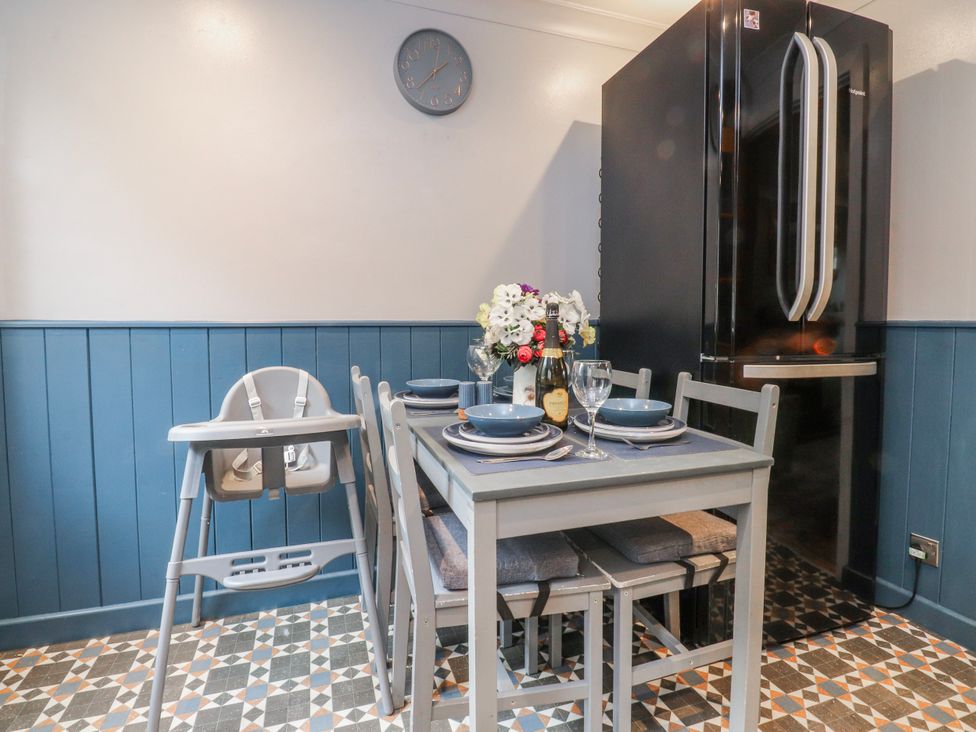 A dining room with a table and high chair at 2 Rock View in Settle