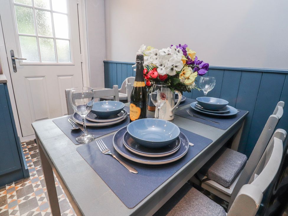 A dining room table set with plates and champagne at 2 Rock View in Settle