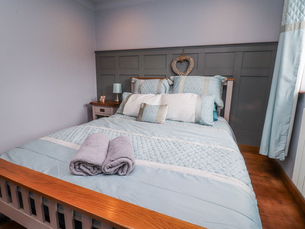 A bedroom with a bed and bedside table at 2 Rock View Settle