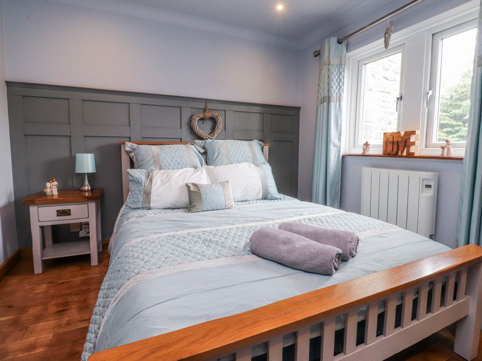 A bedroom with a bed and bedside table at 2 Rock View in Settle