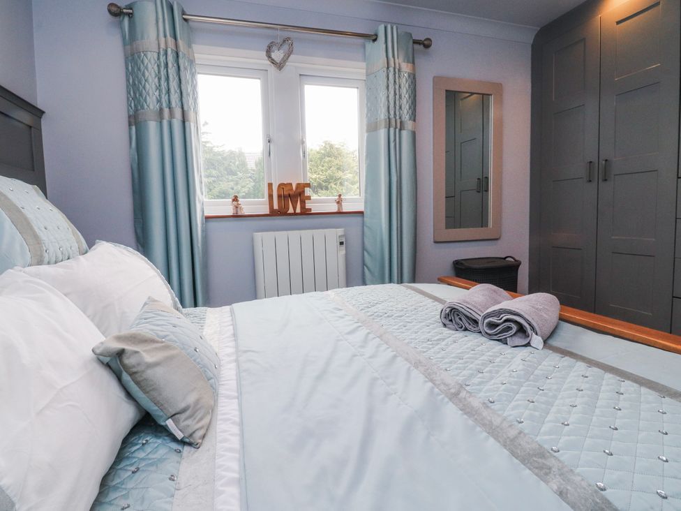 A bedroom with a bed, wardrobe, and window at 2 Rock View in Settle