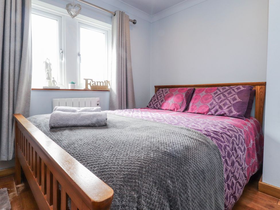 A bedroom with a bed and windows at 2 Rock View Settle