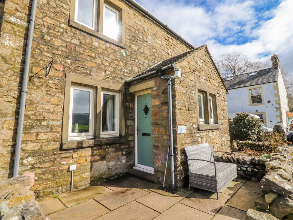 An outdoor area with a stone wall and a chair at 2 Rock View Settle