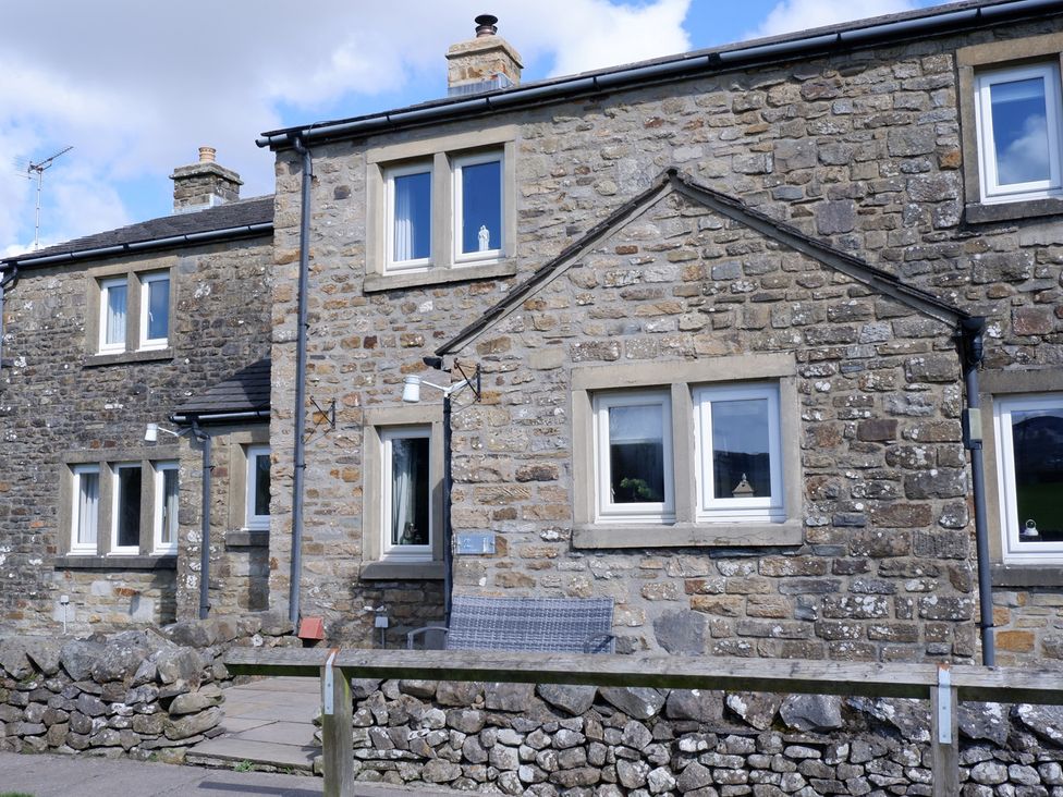 A stone building with multiple windows and a fence at 2 Rock View near Settle