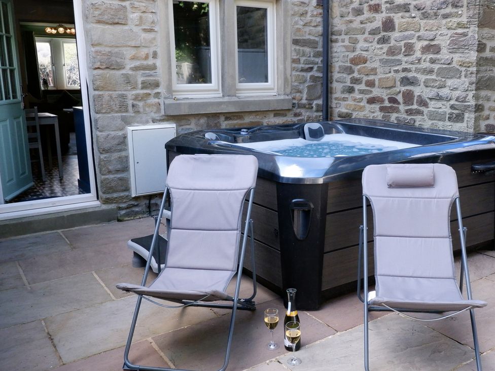 An outdoor area with a hot tub and deck chairs at 2 Rock View near Settle
