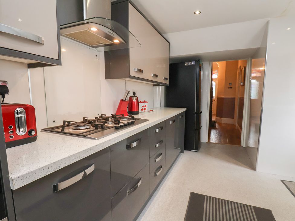 A kitchen with a gas stove and fridge at 30 Prospect Hill, Whitby