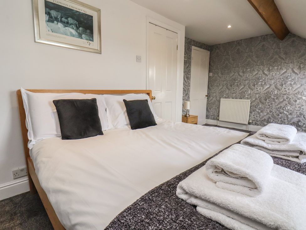 A bedroom with a bed and towels at 30 Prospect Hill in Whitby