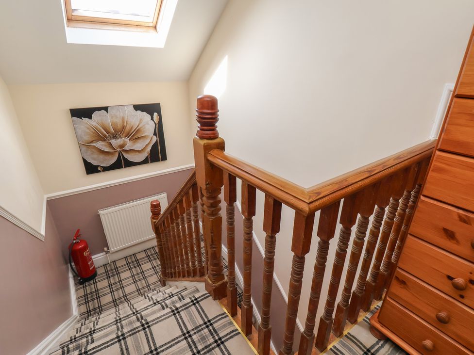 A staircase with a skylight and a wooden railing at 30 Prospect Hill in Whitby