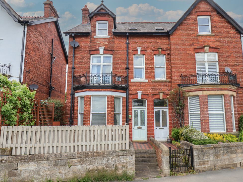 A brick building with multiple windows and a pathway at 30 Prospect Hill Whitby