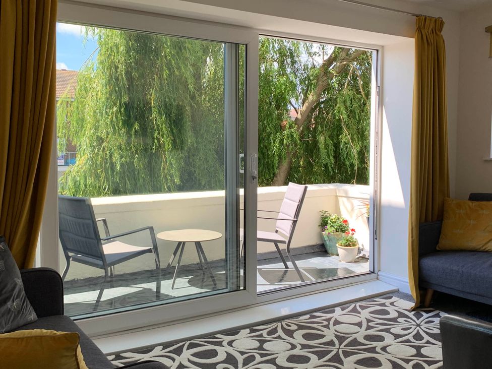 A living room with a view to a balcony at Balcony Apartment near Skegness Beach & Town Skegness