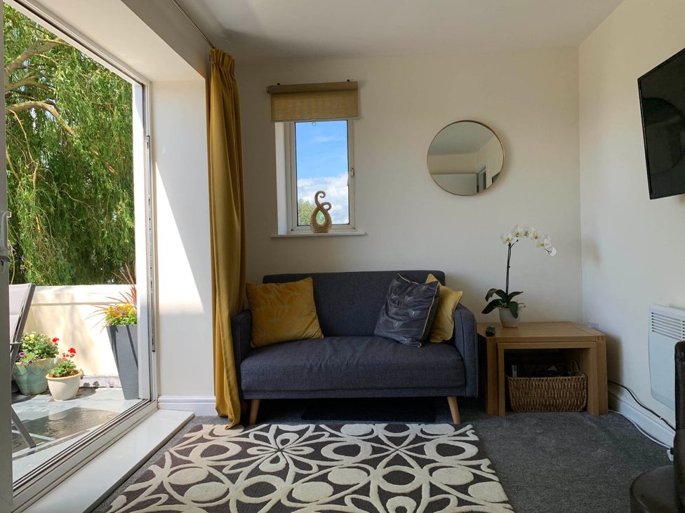 A living room with a sofa and coffee table at Balcony Apartment near Skegness Beach & Town in Skegness