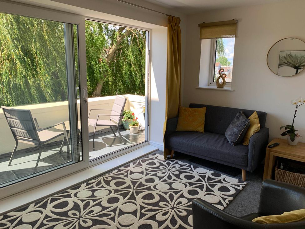 A living room with a sofa and chairs at Balcony Apartment near Skegness Beach & Town Skegness