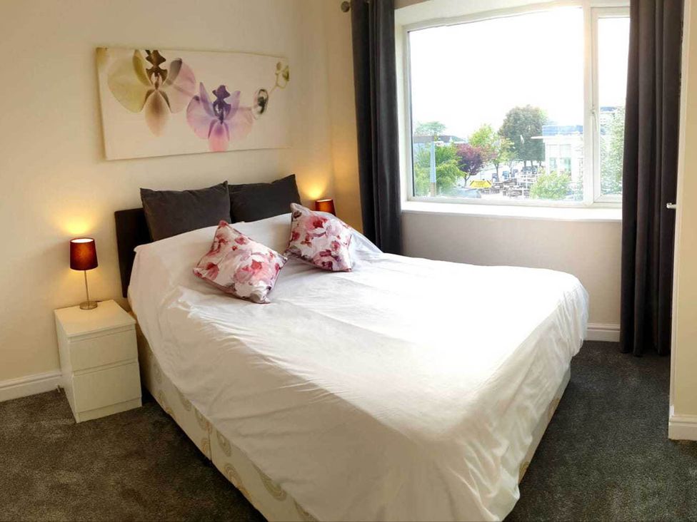 A bedroom with a bed and window at Balcony Apartment near Skegness Beach & Town Skegness