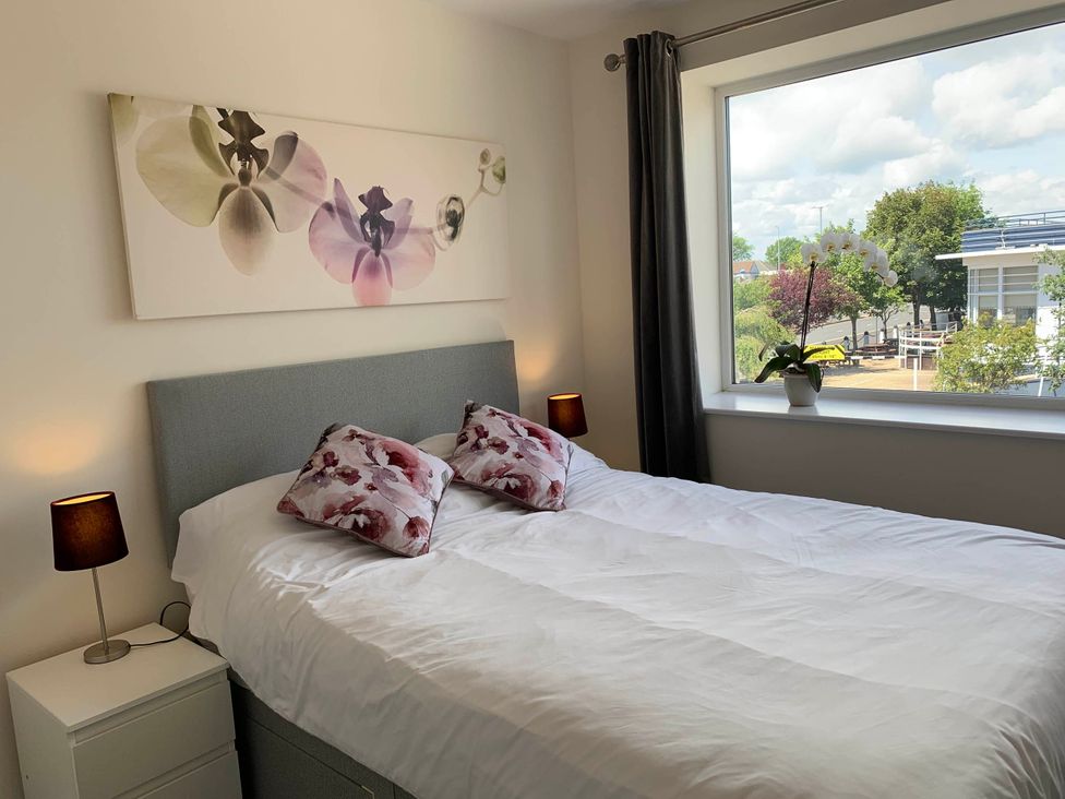 A bedroom with a bed and a window at Balcony Apartment near Skegness Beach & Town, Skegness