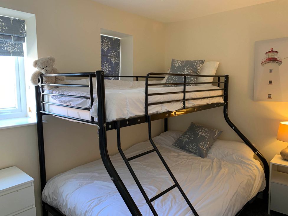 A bedroom with a bunk bed and a teddy bear at Balcony Apartment near Skegness Beach & Town
