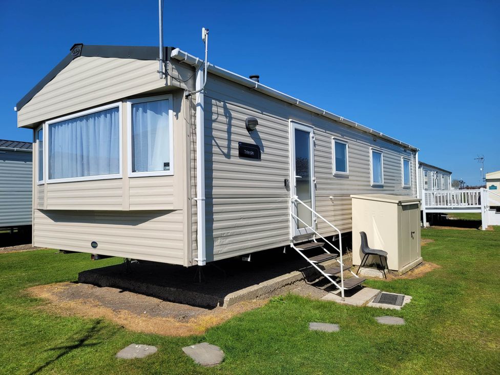 A caravan with a storage unit and a chair at St Osyth- Sleeps8-freeparking-wifi-holidaypark Clacton-On-Sea