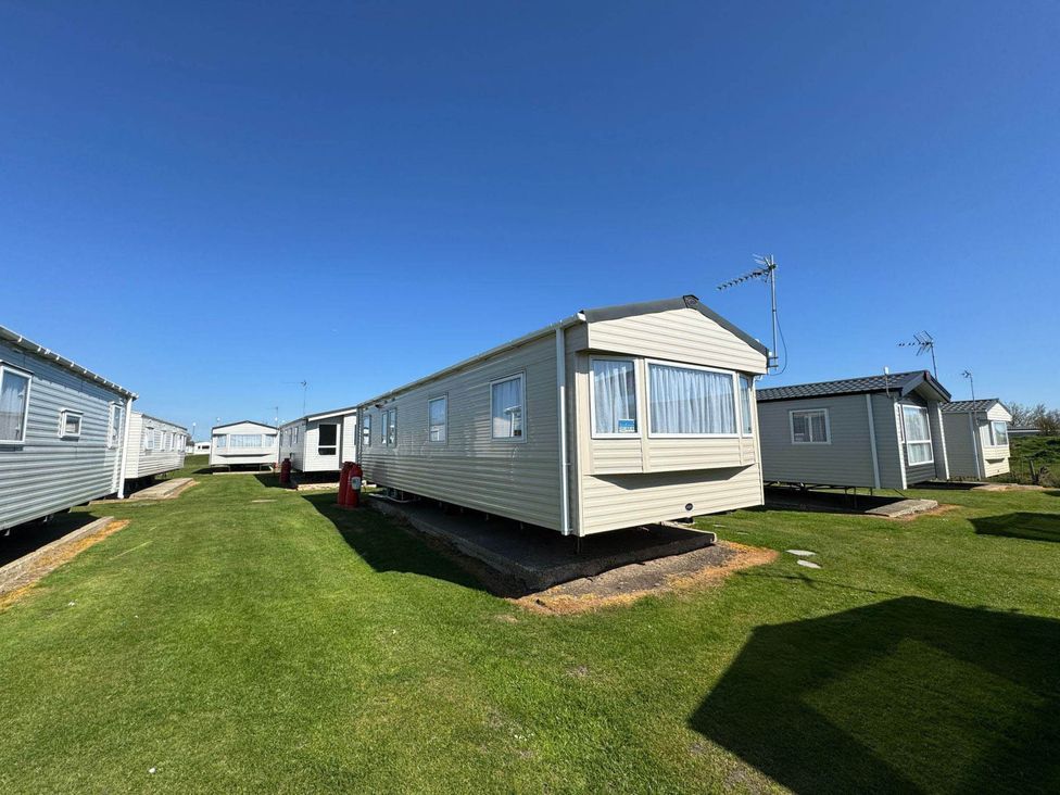 A row of mobile homes on grass at St Osyth- Sleeps8-freeparking-wifi-holidaypark Clacton-On-Sea