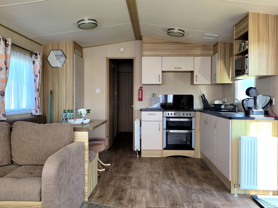 A living room with a sofa and kitchen area at St Osyth- Sleeps8-freeparking-wifi-holidaypark Clacton-On-Sea