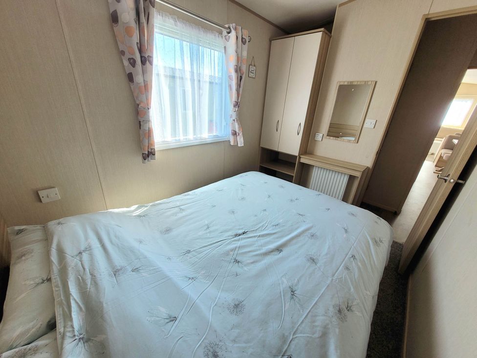 A bedroom with a bed and wardrobe at St Osyth- Sleeps8-freeparking-wifi-holidaypark Clacton-On-Sea